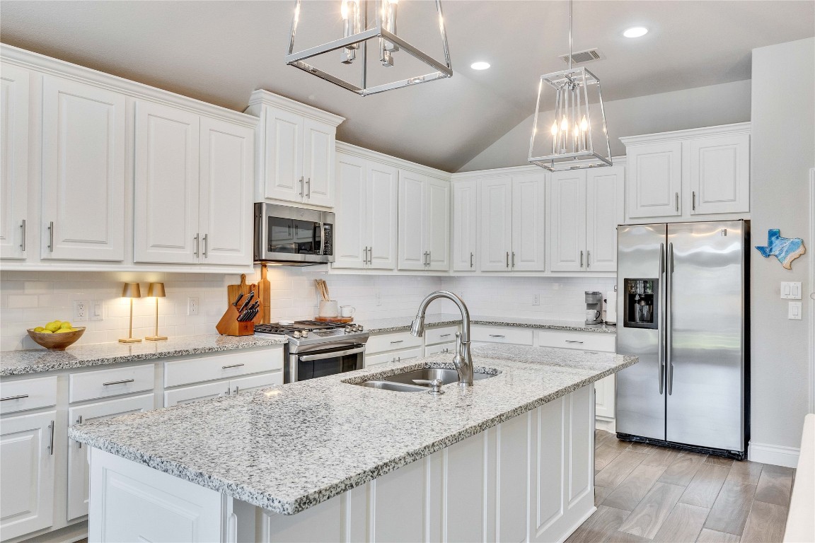 4229 Mercer Road Georgetown, TX 78628 - Photo 11 of 38 Kitchen featuring white cabinetry, a chandelier, appliances with stainless steel finishes, and a sink