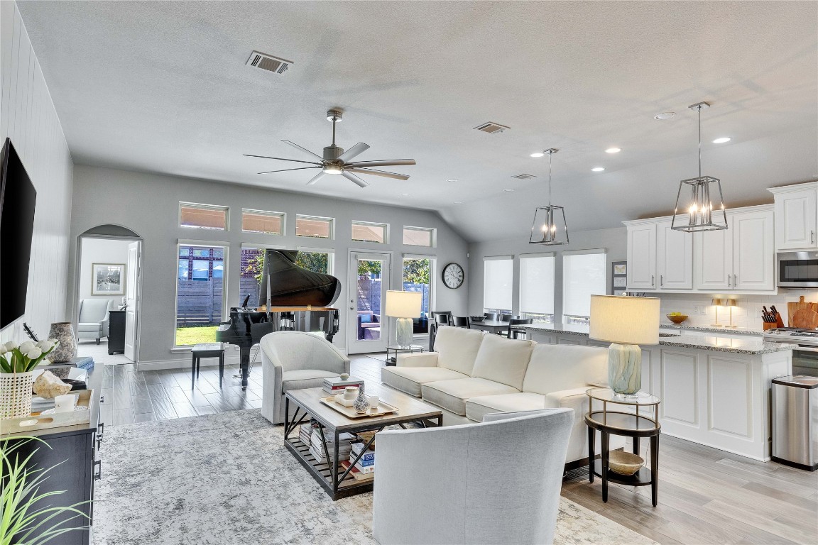 4229 Mercer Road Georgetown, TX 78628 - Photo 2 of 38 Living room featuring visible vents, a ceiling fan, light wood-style flooring, and arched walkways