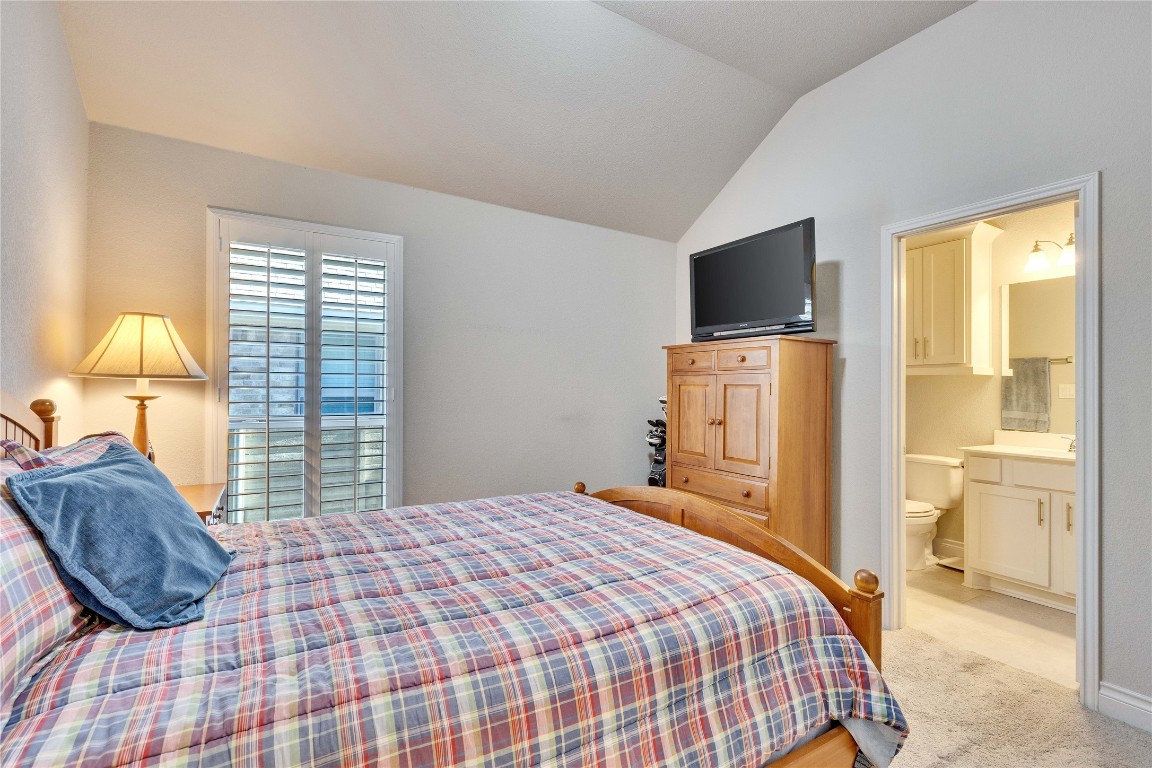 4229 Mercer Road Georgetown, TX 78628 - Photo 21 of 38 Bedroom featuring ensuite bathroom, lofted ceiling, and light carpet