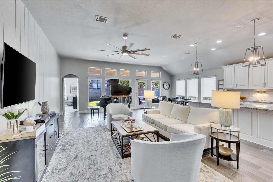 4229 Mercer Road Georgetown, TX 78628 - Photo 4 of 38 Living room with ceiling fan, visible vents, arched walkways, vaulted ceiling, and light wood finished floors