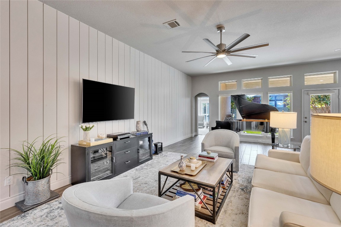 4229 Mercer Road Georgetown, TX 78628 - Photo 7 of 38 Living area with ceiling fan, visible vents, arched walkways, wood finished floors, and baseboards