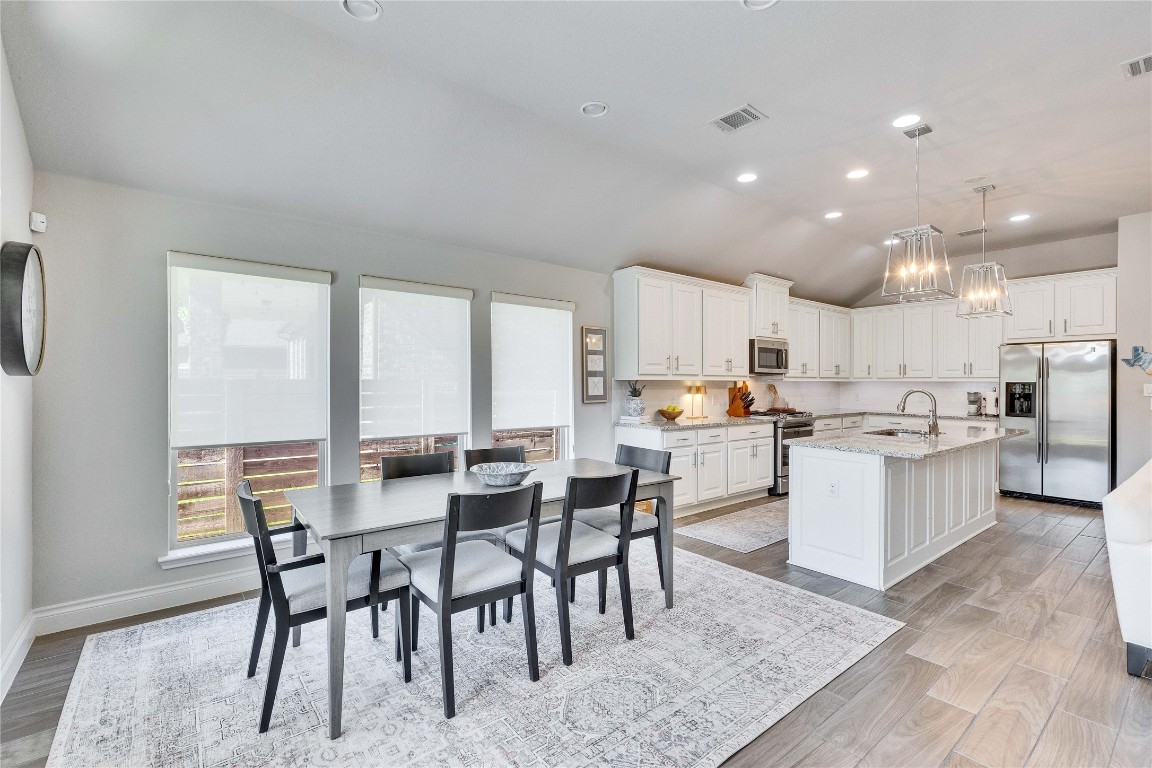 4229 Mercer Road Georgetown, TX 78628 - Photo 9 of 38 Dining area featuring a notable chandelier, visible vents, vaulted ceiling, and light wood-type flooring