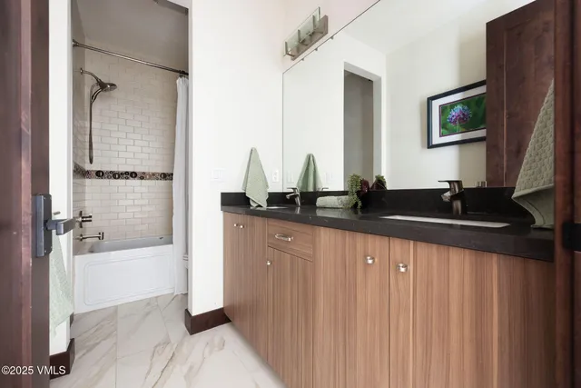 a view of a white house with large windows and a small yard