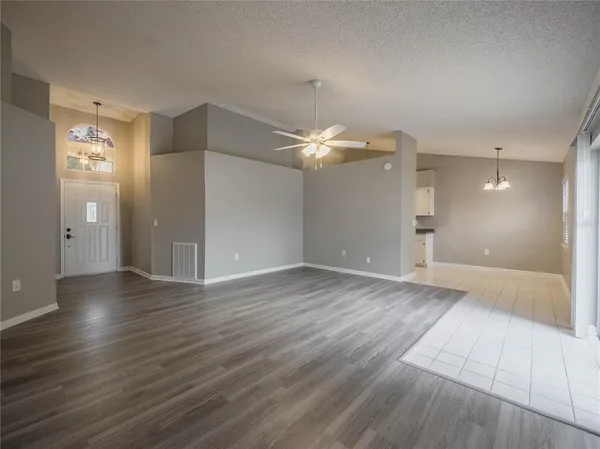 an empty room with wooden floor and mirror
