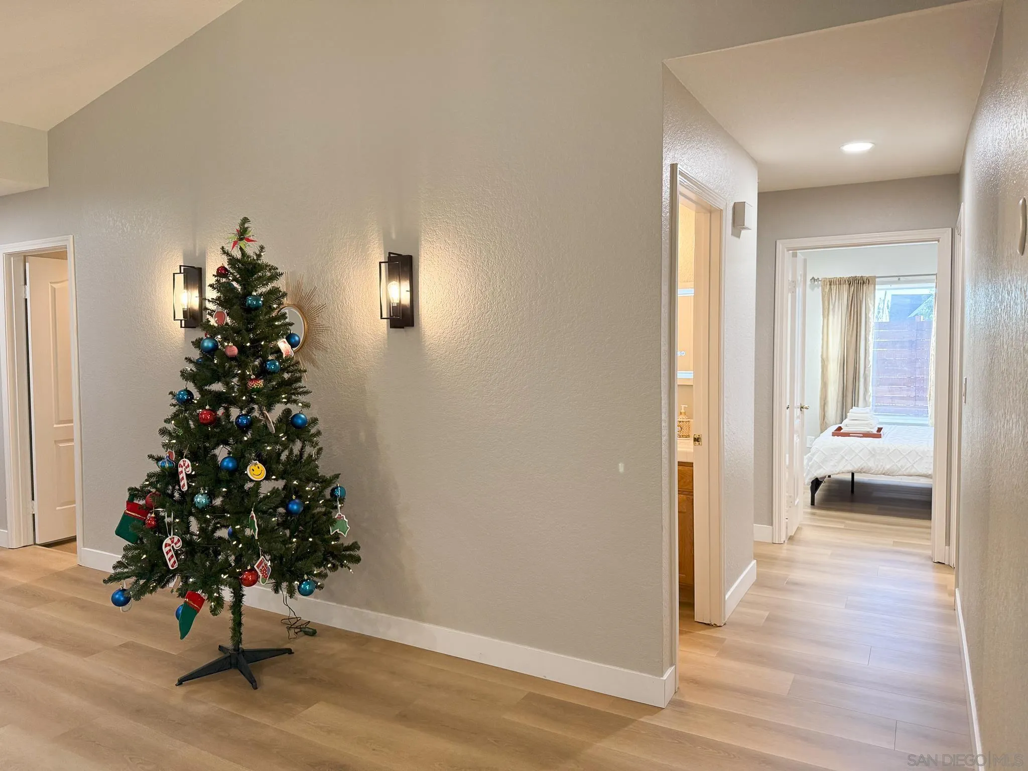1457 Fallsview Place Escondido, CA 92027 - Photo 18 of 41 a view of a hallway with wooden floor and a potted plant