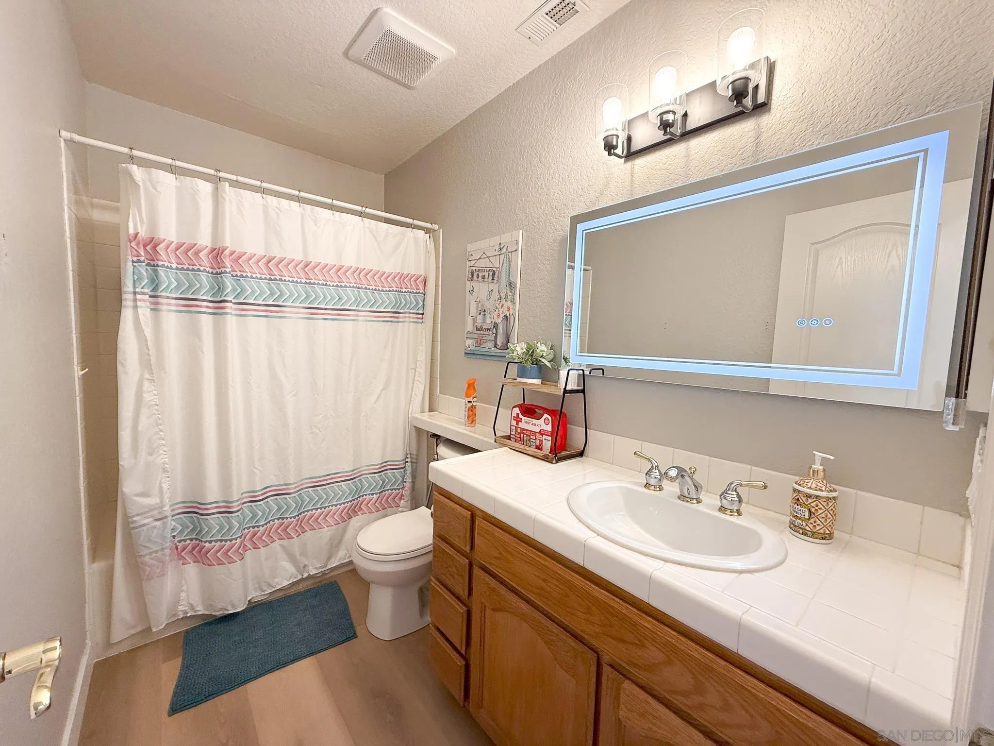 1457 Fallsview Place Escondido, CA 92027 - Photo 19 of 41 a bathroom with a sink toilet mirror and a shower