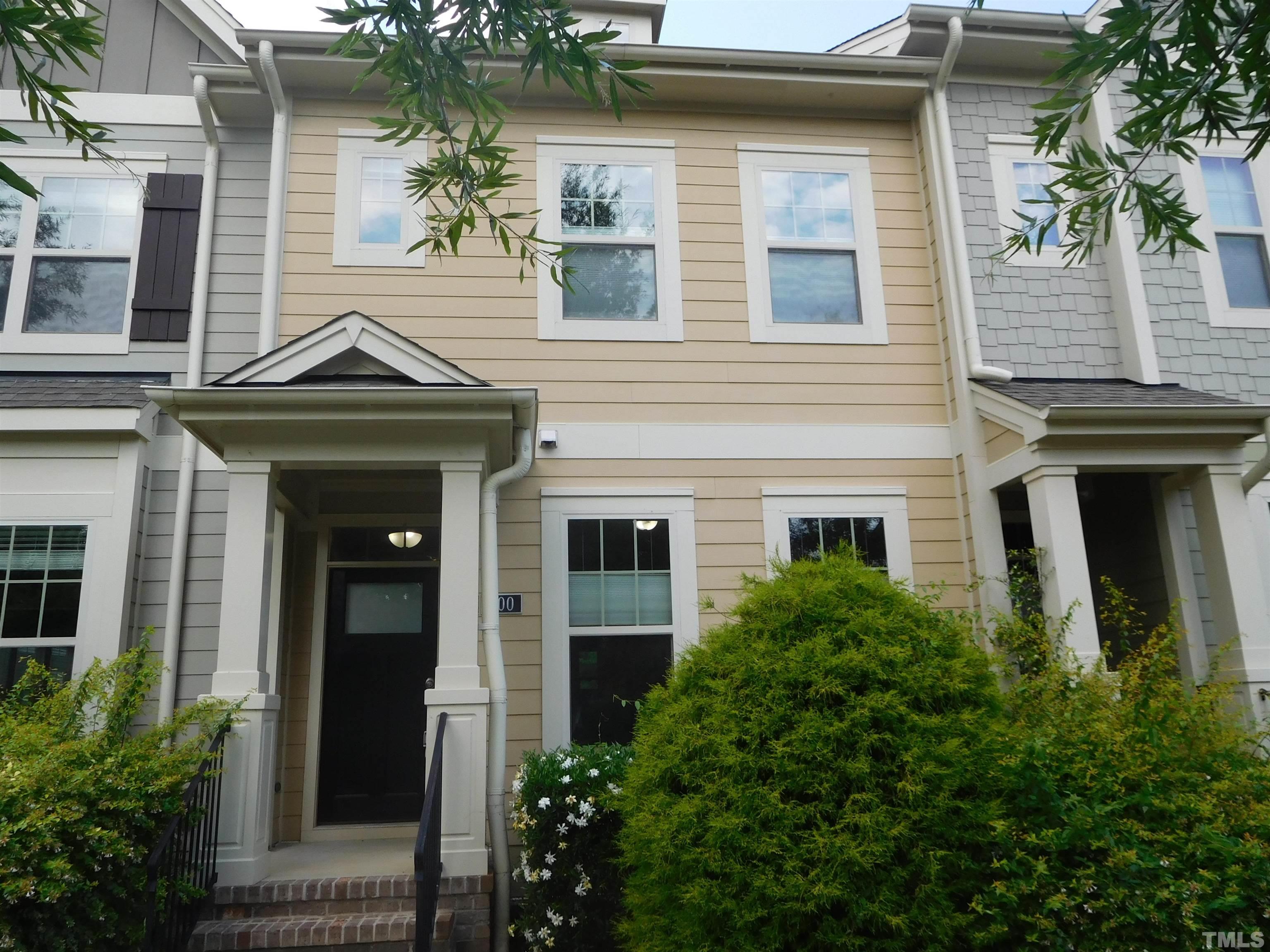 a front view of a house with a yard and potted plants