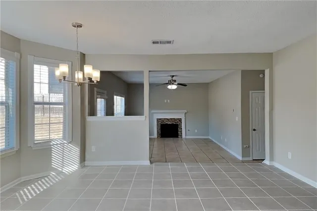 a view of an empty room with a fireplace and a window