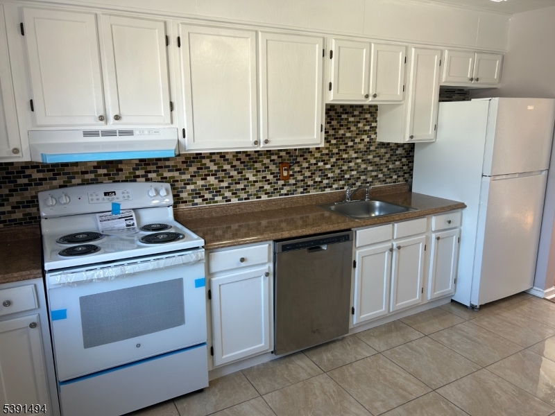63 Troy Drive, Unit A Springfield, NJ 07081 - Photo 3 of 8 a kitchen with white cabinets and white appliances