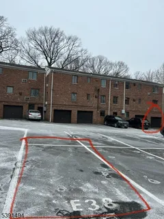 a front view of a building with cars parked