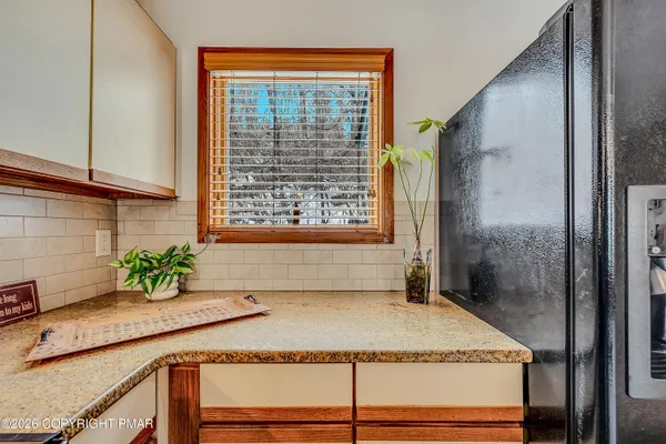 a bathroom with a granite countertop sink a mirror and shower