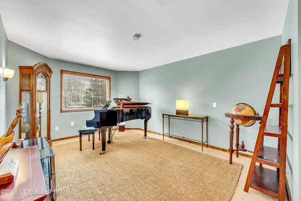 a living room with furniture a piano and a flat screen tv