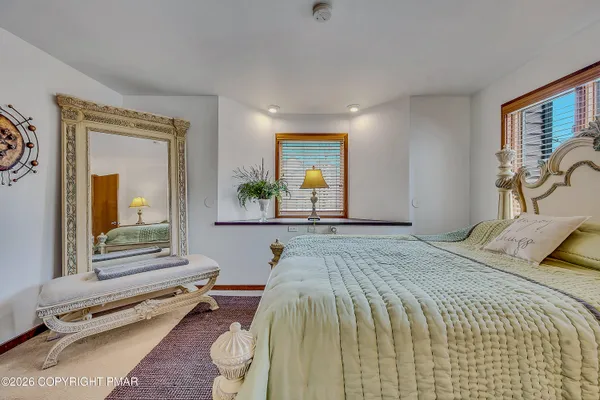 a bedroom with a bed and a dresser next to a window