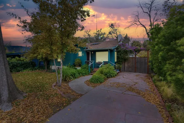a front view of a house with a yard and tree s