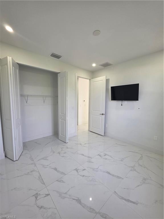 331 Nelson Road North Cape Coral, FL 33993 - Photo 14 of 29 Room featuring large format tile flooring, recessed ceiling lighting, and a single window