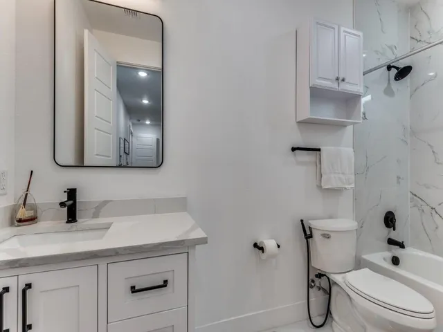a bathroom with a toilet sink and mirror