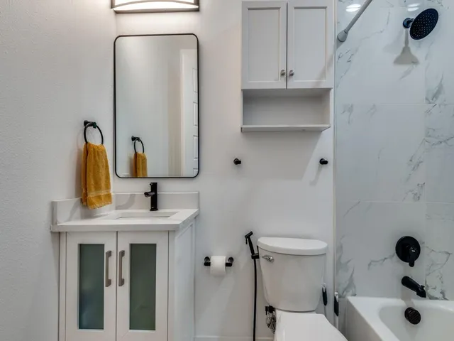 a bathroom with a sink and mirror with toilet