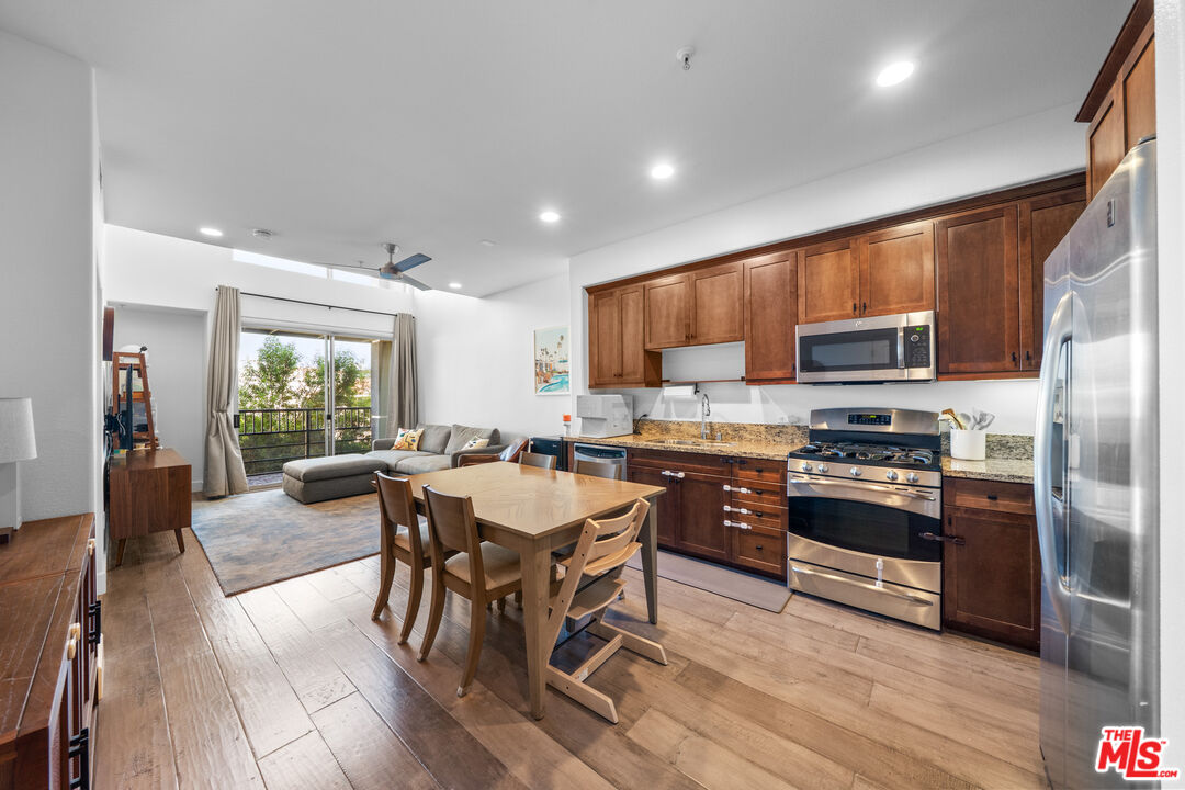 629 Traction Avenue, Unit 233 Los Angeles, CA 90013 - Photo 2 of 41 a kitchen with stainless steel appliances granite countertop a refrigerator a stove a sink a dining table and chairs