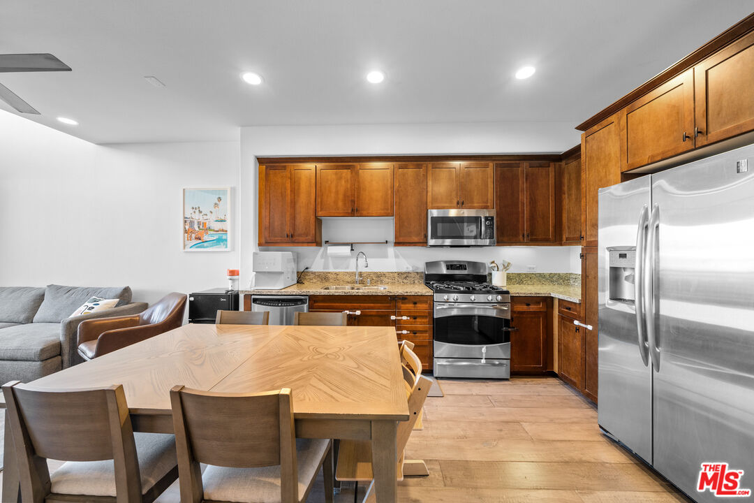 629 Traction Avenue, Unit 233 Los Angeles, CA 90013 - Photo 6 of 41 a kitchen with stainless steel appliances granite countertop a stove top oven a refrigerator a sink and a dining table