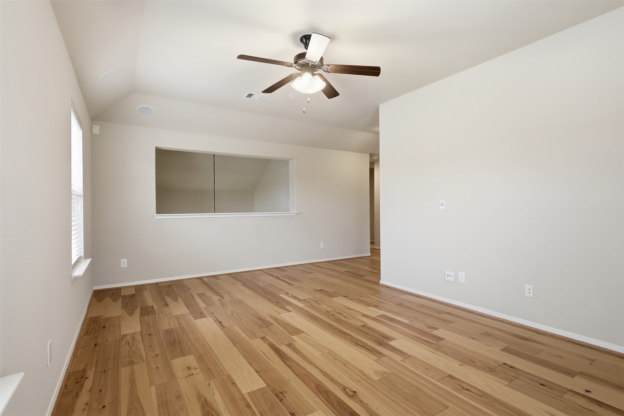 22943 Dale River Road Tomball, TX 77375 - Photo 24 of 29 an empty room with wooden floor ceiling fan and windows