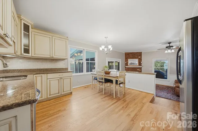 a kitchen with stainless steel appliances a dining table chairs stove refrigerator and microwave