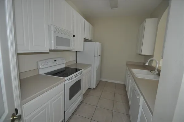 a kitchen with a stove sink and cabinets