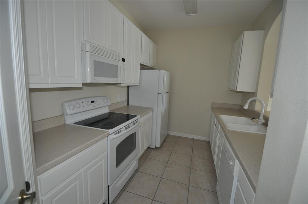 588 Brantley Terrace Way, Unit 305 Altamonte Springs, FL 32714 - Photo 2 of 13 a kitchen with a stove sink and cabinets