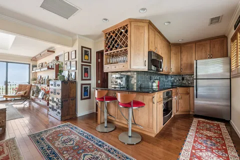 a kitchen with stainless steel appliances granite countertop a stove a refrigerator and wooden cabinets