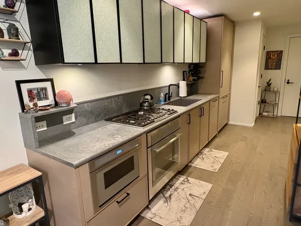 a kitchen with stainless steel appliances granite countertop a stove a sink and a microwave