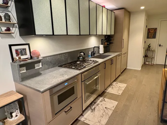 a kitchen with stainless steel appliances granite countertop a stove a sink and a microwave