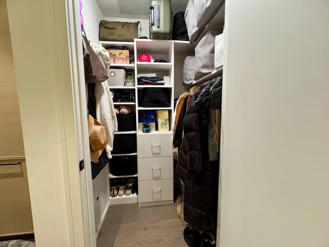 a view of walk in closet with clothes and shoes