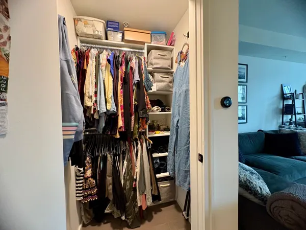 a view of walk in closet with clothes and shoes
