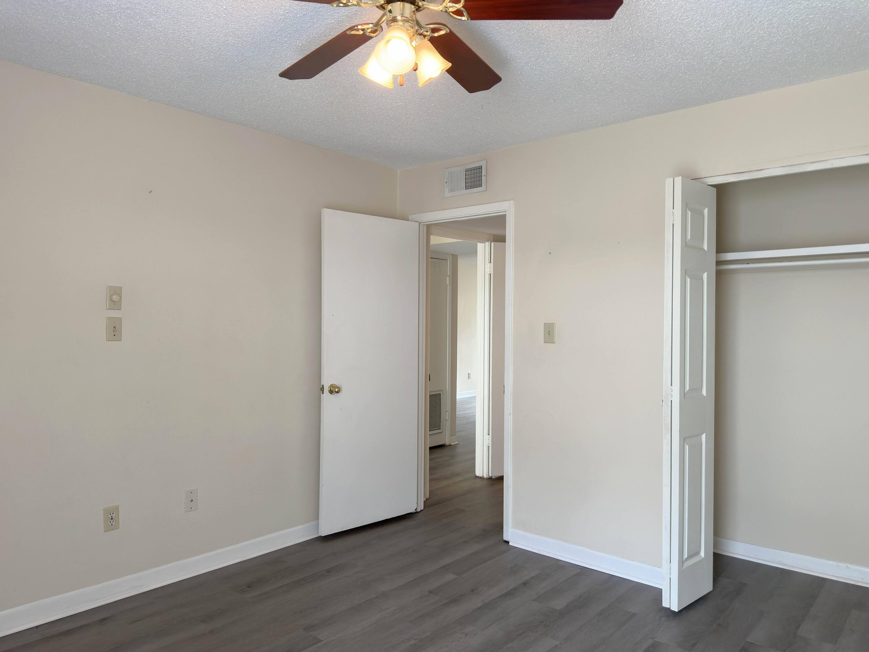 210 Pelham Road, Unit 103B Fort Walton Beach, FL 32547 - Photo 12 of 19 an empty room with wooden floor closet and windows