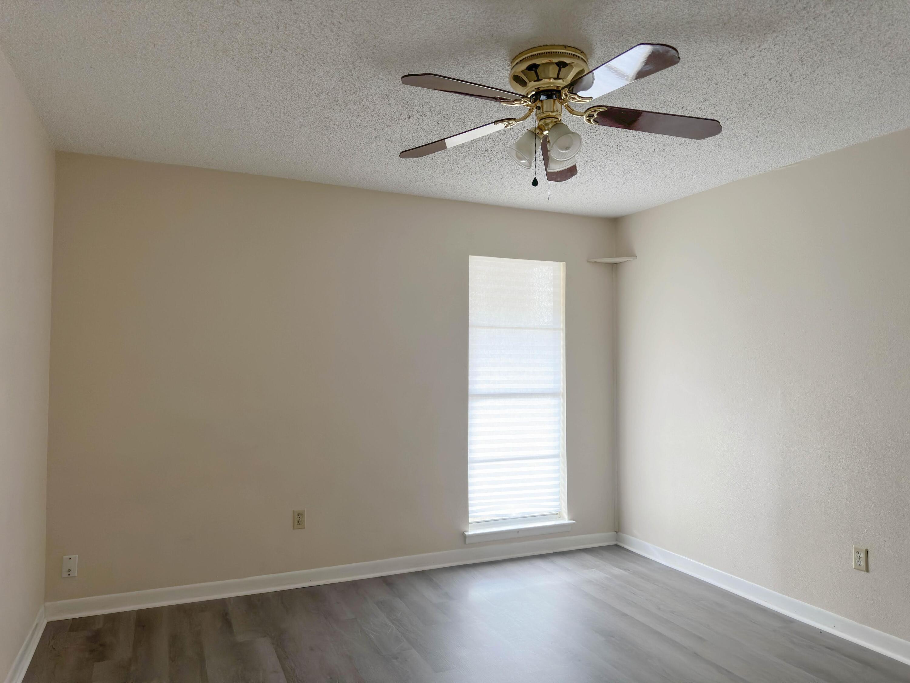 210 Pelham Road, Unit 103B Fort Walton Beach, FL 32547 - Photo 13 of 19 an empty room with window and a ceiling fan