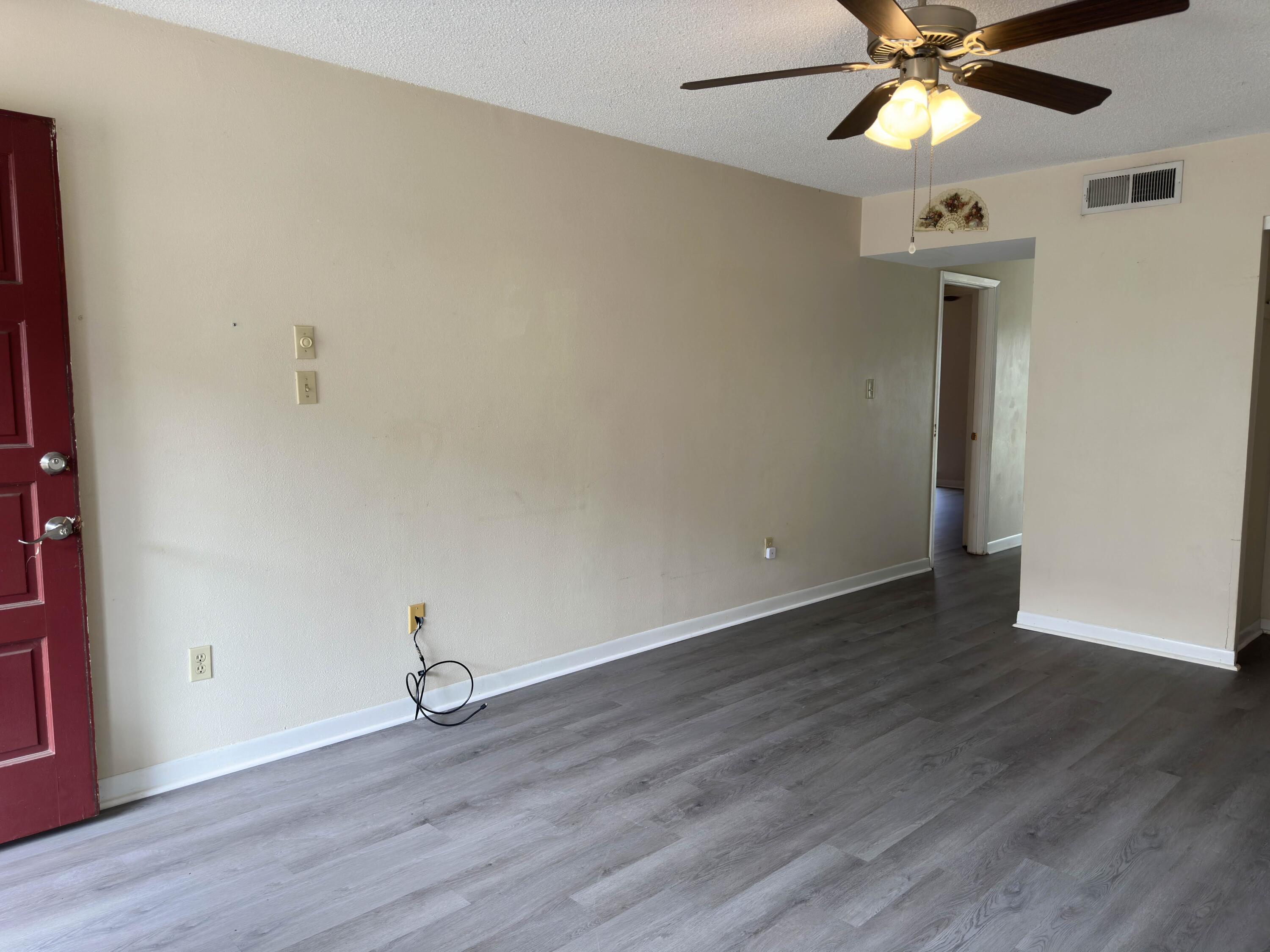 210 Pelham Road, Unit 103B Fort Walton Beach, FL 32547 - Photo 4 of 19 wooden floor in an empty room with a window