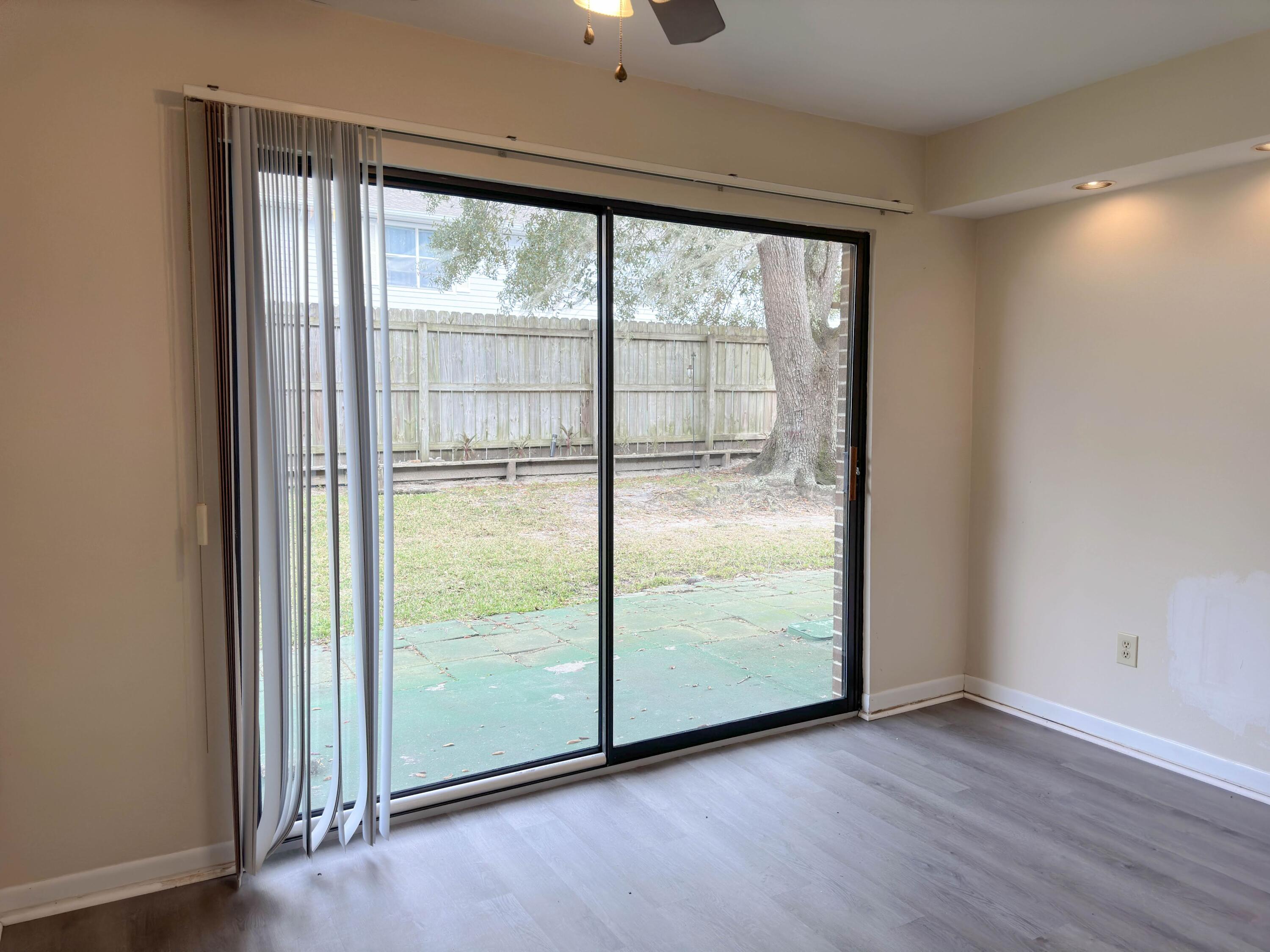 210 Pelham Road, Unit 103B Fort Walton Beach, FL 32547 - Photo 6 of 19 an empty room with wooden floor and windows