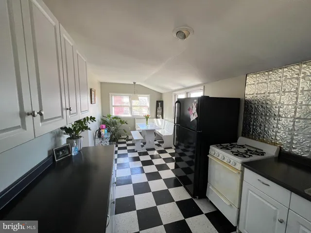 a kitchen with a sink a refrigerator and cabinets