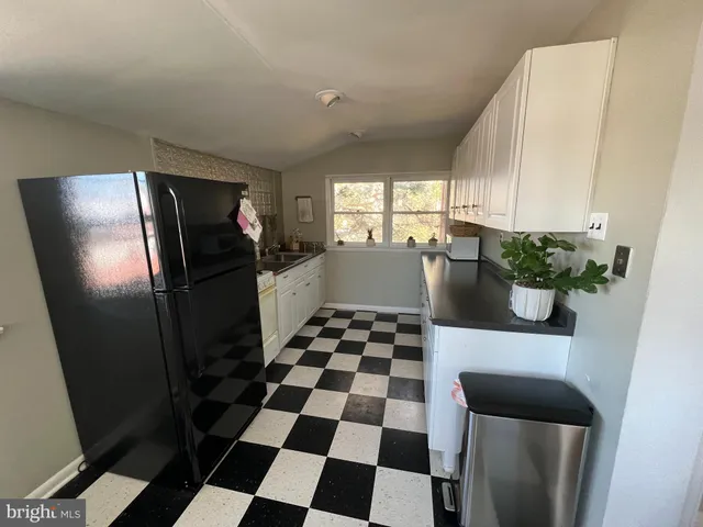 a kitchen with a checkered floor and a refrigerator