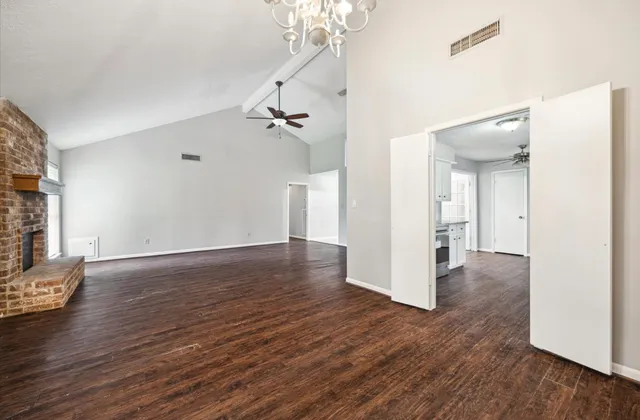 a view of a room with wooden floor and white walls