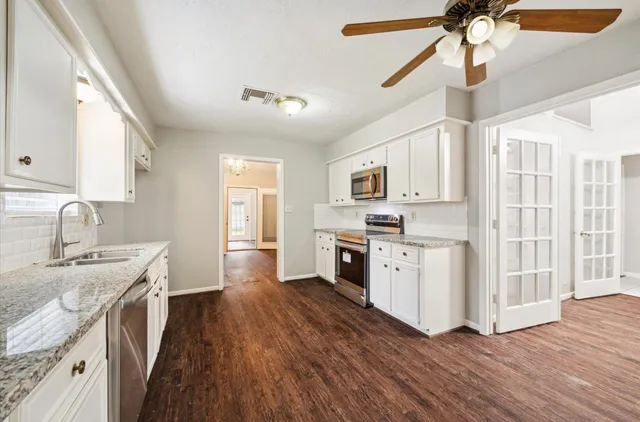 a kitchen with stove a sink and dishwasher with wooden floor