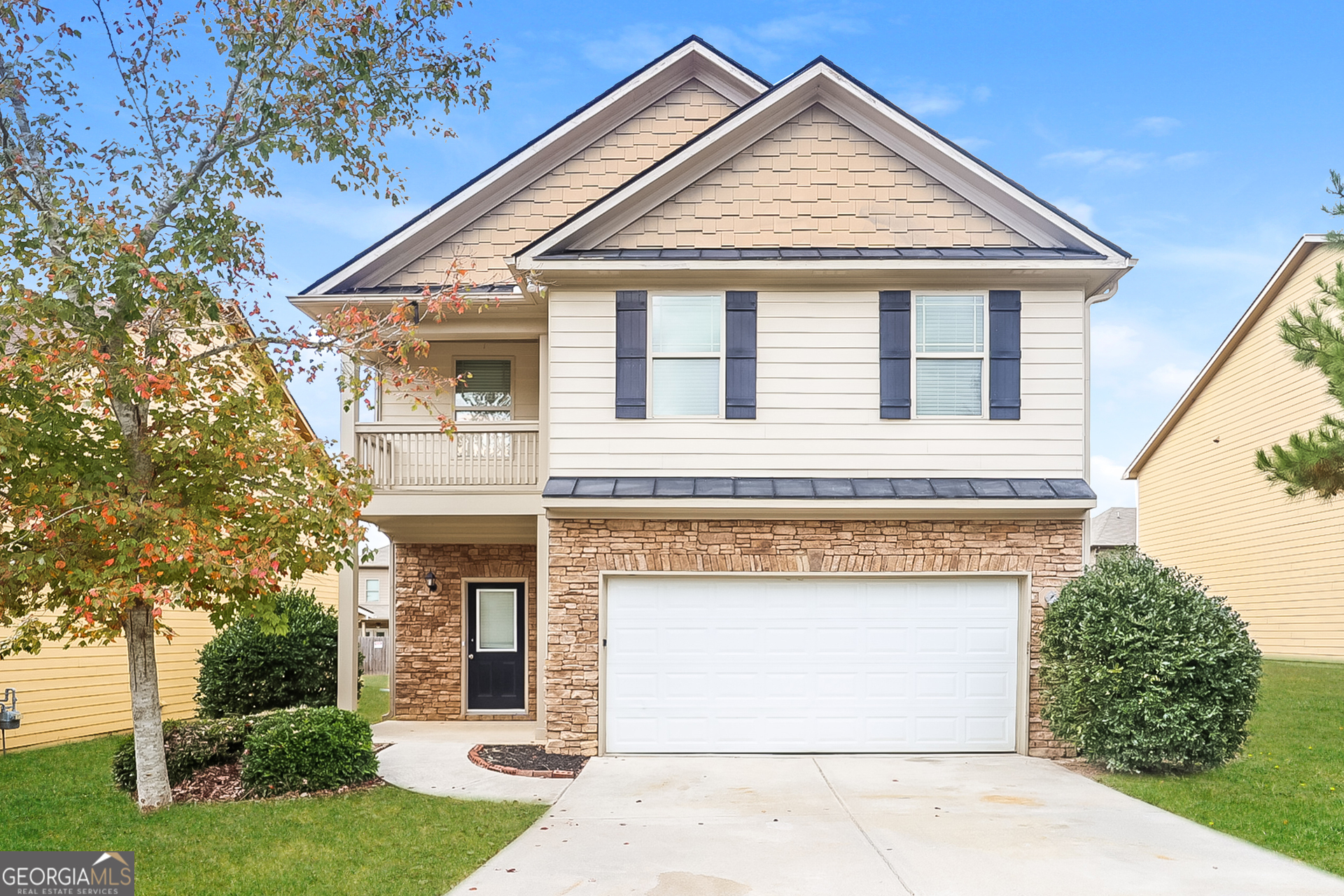 a front view of a house with a garden and garage