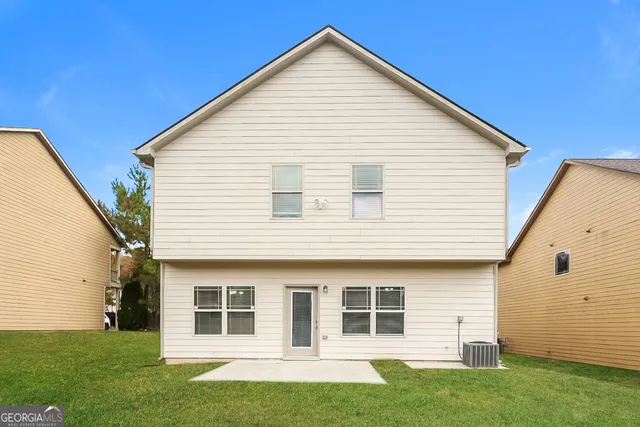 a view of a yard in front of a house with a large tree