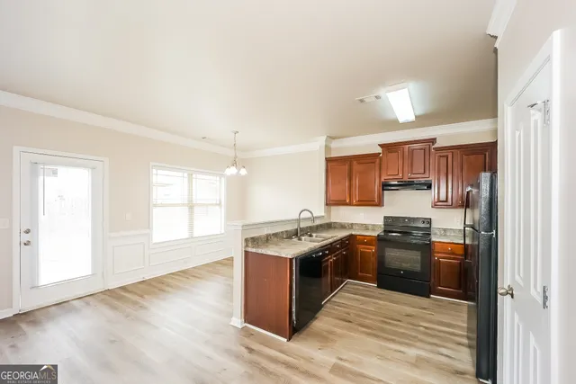 a kitchen with stainless steel appliances granite countertop hardwood floor sink stove and granite counter top