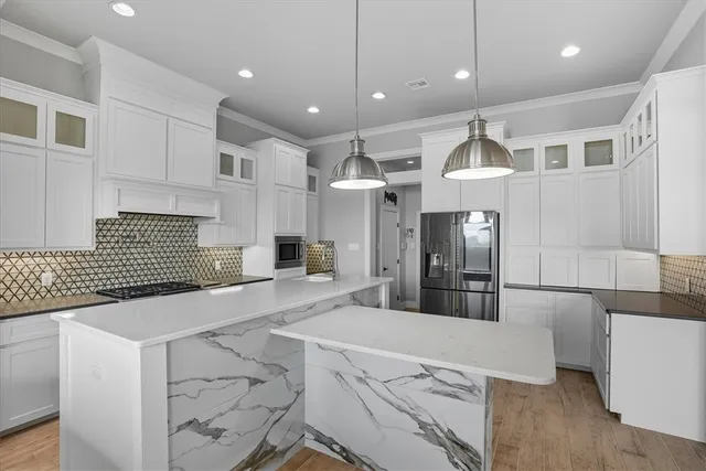 a kitchen with stainless steel appliances kitchen island granite countertop a sink and a refrigerator