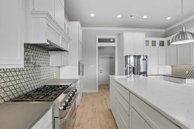 a kitchen with kitchen island a counter top space a sink stainless steel appliances and cabinets