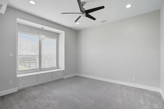 an empty room with a window and a fan