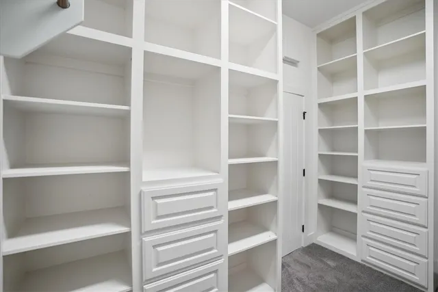 a view of walk in closet with empty racks