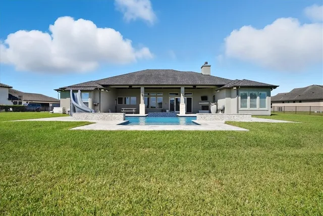 a front view of a house with swimming pool yard and patio