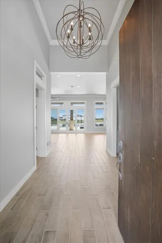 a view of a hallway to a livingroom with wooden floor