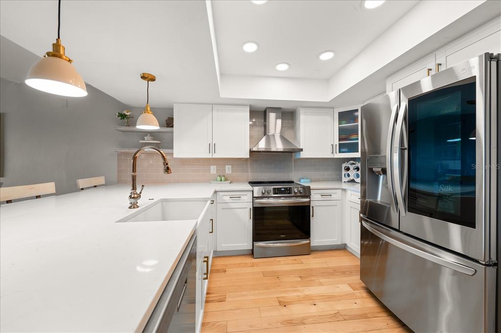 2515 Bay Boulevard, Unit B Indian Rocks Beach, FL 33785 - Photo 15 of 66 a kitchen with stainless steel appliances granite countertop a sink and a refrigerator
